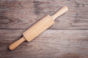 Wooden rolling pin on wooden table top view