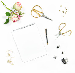 Flat lay with sketchbook, flowers, office tools