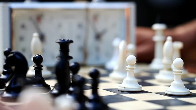 men playing chess outdoors    /    men playing chess outdoors, vintage pieces, concept passion and competition, close-up
