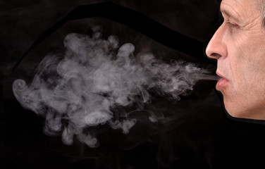 Fototapeta na wymiar Retrato de un hombre fumando,botando humo por la boca