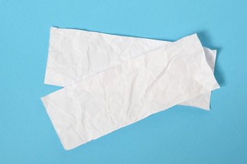 Obraz premium white ripped pieces of news paper on on blue background.