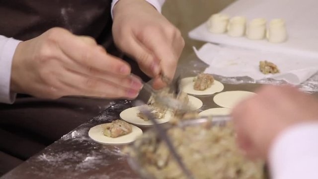 Womens cooking dumplings with meat. 