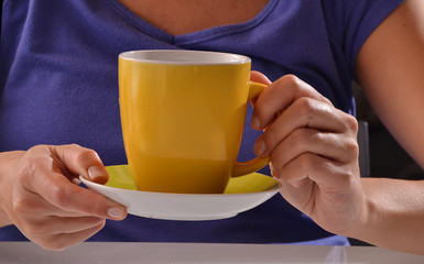 Mujer sujetando una taza de cafe o te caliente.