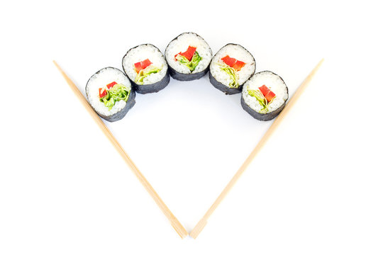 Sushi between chopsticks for sushi isolated on white background. Top view. 