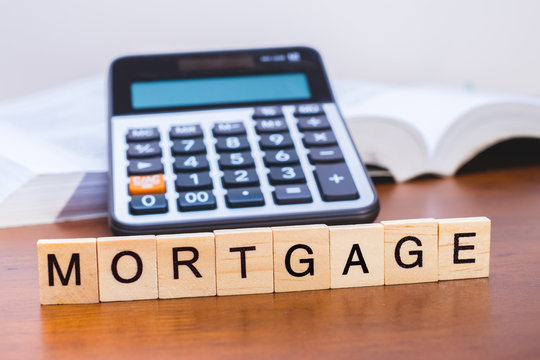 Calculator with the word "Mortgage" written in wooden block letters