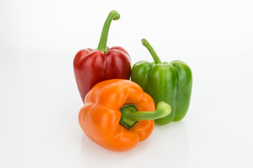 Fresh orange, green and red bell peppers, isolated on white background.Fresh orange, green and red bell peppers, isolated on white background.