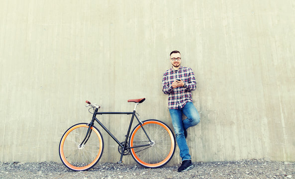 hipster man in earphones with smartphone and bike