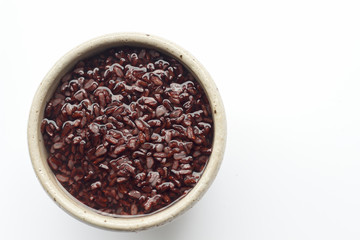 gruel (dark violet rice)  in ceramic bowl isolated on white background (top view)