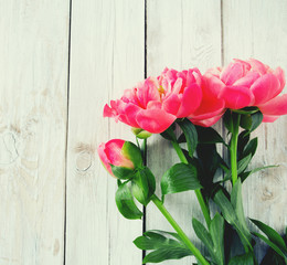beautiful peonies on wooden surface