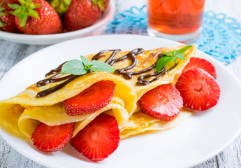 Pancakes with sliced strawberries and chocolate