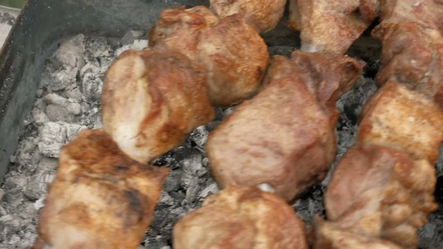 Barbeque skewers with meat cooking on hot coal ember brazier Outdoors picnic concept. 4K UHD video footage.