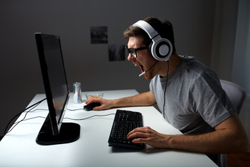 man in headset playing computer video game at home © Syda Productions