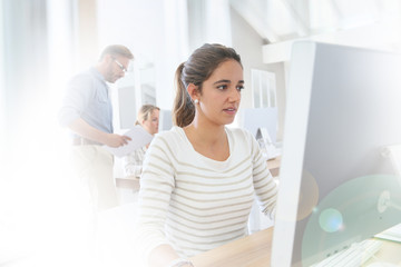 Obraz premium Student girl working on desktop computer at school