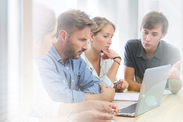 Teacher with group of students working on laptop computer