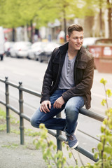 young blond man sitting outside