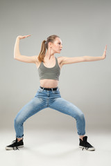 Girl in pose of martial arts over grey background