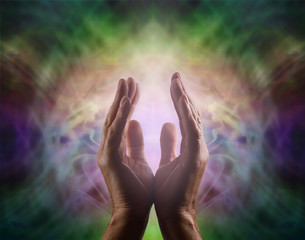 Pranic healer with beautiful Aura -  Complex multicolored vignette energy field with male hands reaching up and a gentle pink light between 