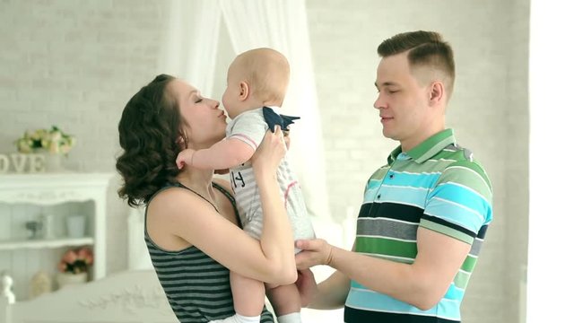 Mom dad and 6 month old baby. Happy family playing with a child. Family play with infant.