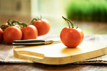 Tomatoe on wood voard with knife - selective focus