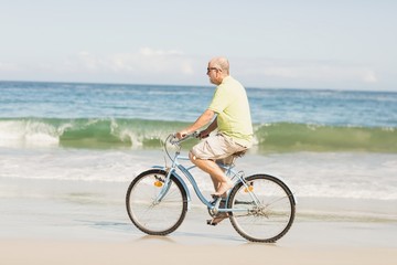 Smiling senior man riding bike