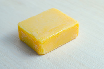 Soap bar flavor with mango ingredient isolated on wooden board b