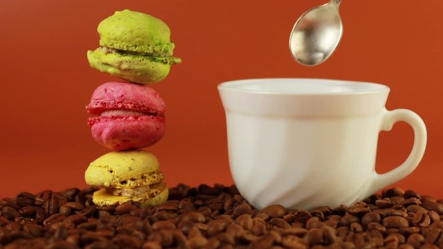 Macrons with cup of coffee on a brown background