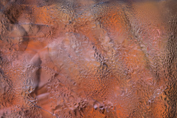 Water droplets on the glass with a colored background