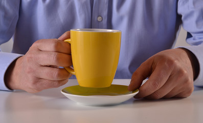 Hombre sujetando una taza de cafe.