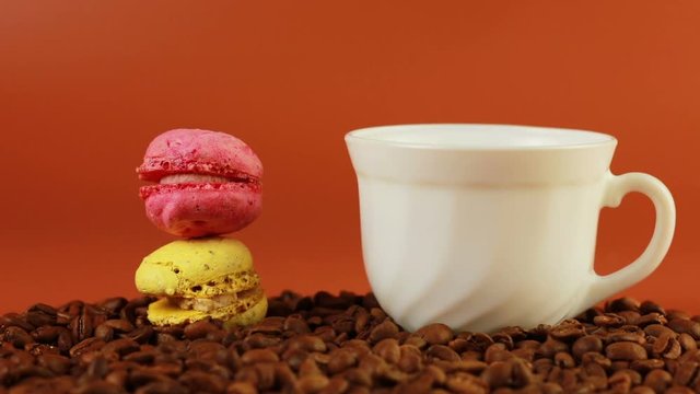 Macrons with cup of coffee on a brown background