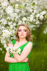 Naklejka premium Beautiful happy young woman in spring blossoming garden