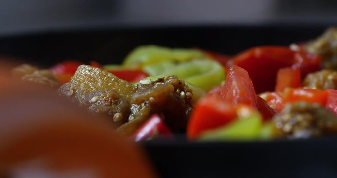 View to the frying pan with following focus on vegetables stewing there. Mix of peppers, tomatoes and egg-plants for tasty and healthy dinner