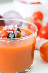 Gazpacho soup and ingredients on white wooden background
