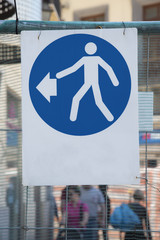 cartello stradale che indica percorso obbligato a sinistra per pedoni 