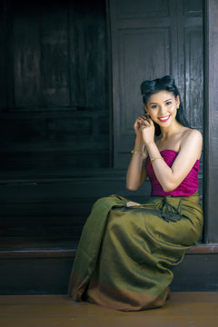 Woman wearing typical thai dress with thai style home background
