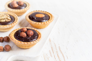 Nutty chocolate dessert small tarts  on a white background, spac