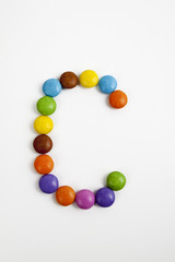 La lettera C formata da coloratissimi confetti di cioccolato.