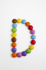 La lettera D formata da coloratissimi confetti di cioccolato.