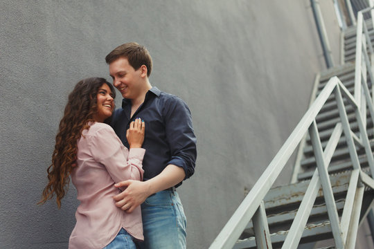 Young couple hugging while sitting on staircase