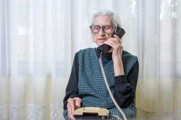 Elderly woman using the phone indoors
