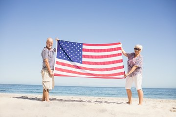 Senior couple holding american flag together
