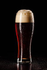 Beer Glass with DROPS on black. FRESH! MUCH FOAM! Beer bubbles closeup. DRAFT. Overflow beer glass. Beer beverage. Glass of alcohol. Closeup Cold Beer. Pint of beer. Good for brewery commercial