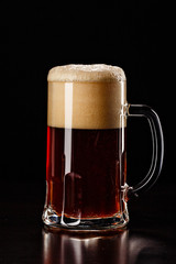Beer Glass with DROPS on black. FRESH! MUCH FOAM! Beer bubbles closeup. DRAFT. Overflow beer glass. Beer beverage. Glass of alcohol. Closeup Cold Beer. Pint of beer. Good for brewery commercial