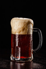 Beer Glass with DROPS on black. FRESH! MUCH FOAM! Beer bubbles closeup. DRAFT. Overflow beer glass. Beer beverage. Glass of alcohol. Closeup Cold Beer. Pint of beer. Good for brewery commercial