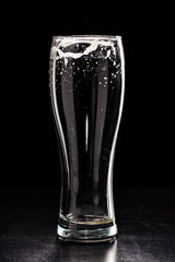 USED EMPTY Beer Glass with DROPS on black. FRESH! MUCH FOAM! Beer bubbles closeup. DRAFT. Overflow beer glass. Glass of alcohol. Closeup Cold Beer. Pint of beer. Good for brewery commercial