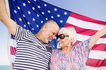 Senior couple holding american flag together