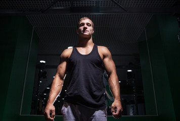 Fototapeta na wymiar Handsome muscular bodybuilder looking at camera