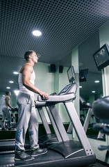 Side view of man on track in gym