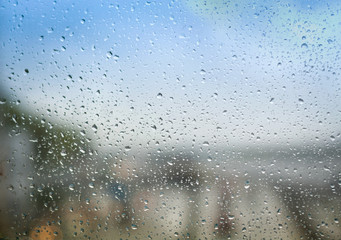 Blurry backdrop. Rainy window. View from window to cityscape. Summer autumn rain. Weather template.  