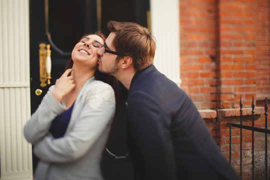 young couple kissing in front of their new home