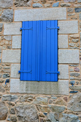 Volet bleu sur un mur de pierres den granit de Bretagne